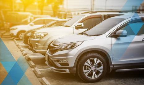line of silvery vehicles with a sun-type lighting shining on them